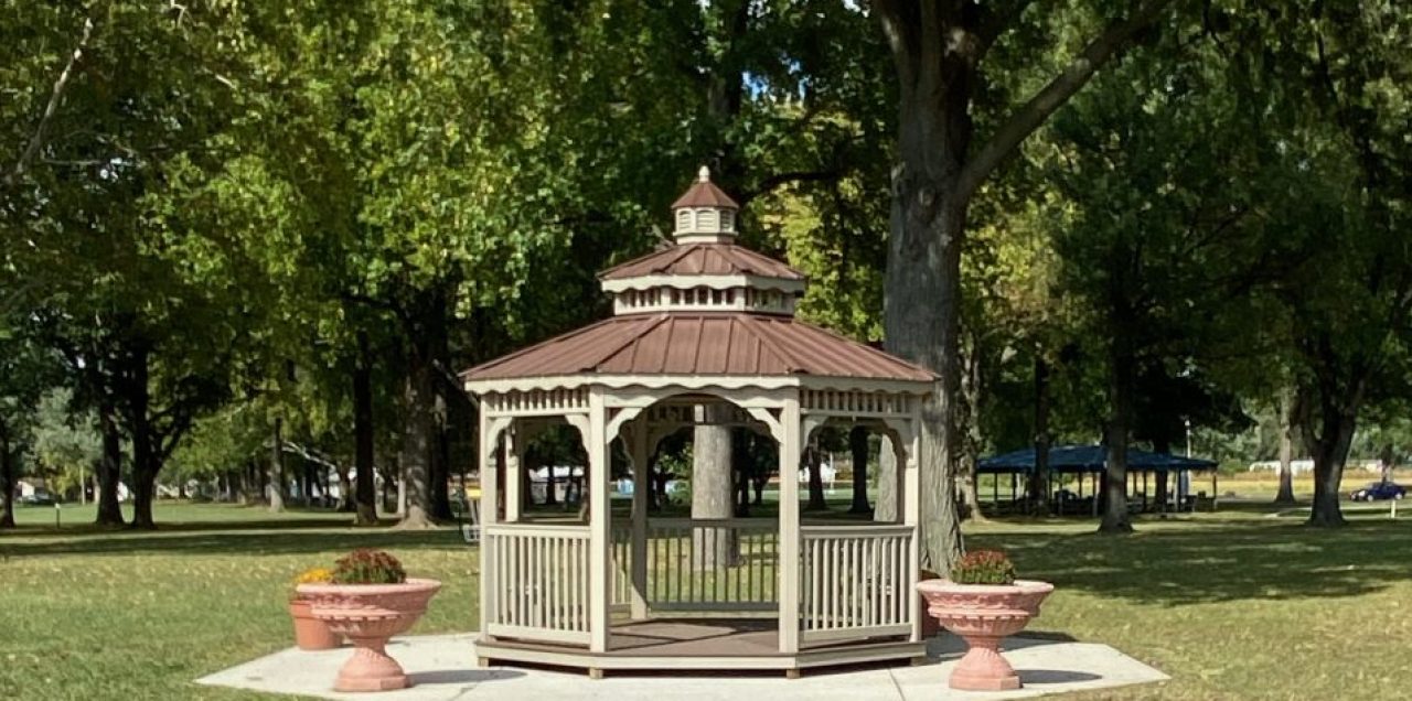 White gazebo surrounded by mature trees at Roxana Community Park
